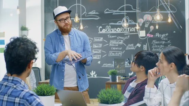 Charismatic Team Leader Talks with His Team of Progressive Engineers about Renewable Energy, He's Holding Extra Efficient Prototype of the Solar Panel. Shot on RED EPIC-W 8K Helium Cinema Camera.