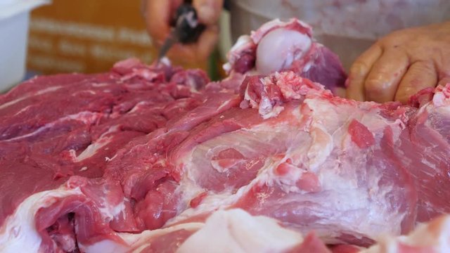 Butcher cutting fresh pork becon in Slaughterhouse. 