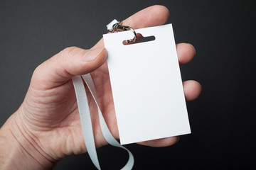 Close up, hand holding Identification white blank plastic id card, mockup.