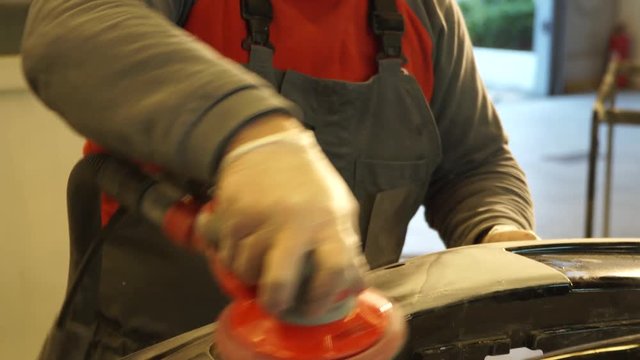 painter grinds car bumper