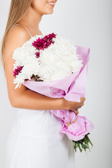 Close-up delicate woman hands holding bunch of flowers 