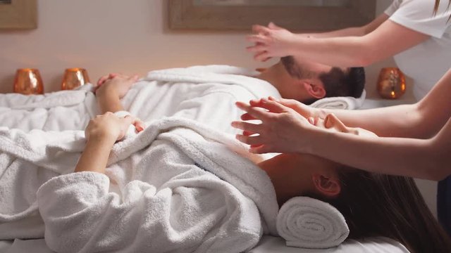 Couple enjoying a face massage in spa center.