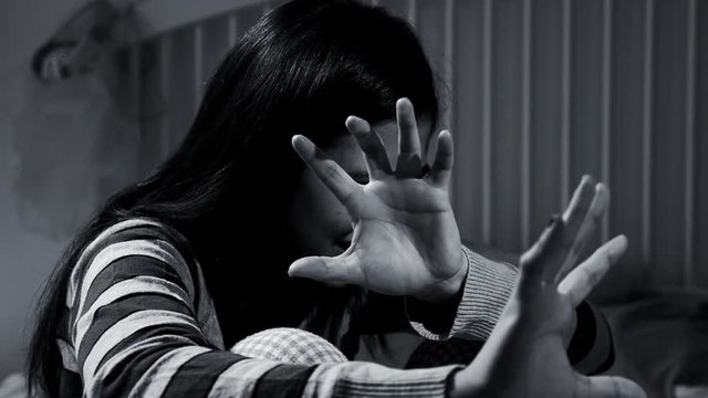 Woman at home scared shaking fear of domestic violence slow motion black and white