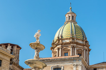 Fototapeta na wymiar View of San Giuseppe dei Teatini church dome with statue of the Pretoria fountain ahead in Palermo, Sicily, Italy