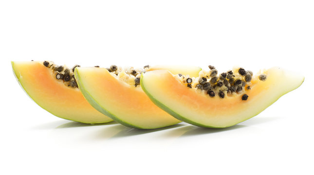Green papaya (pawpaw, papaw) three slices with seeds isolated on white background.