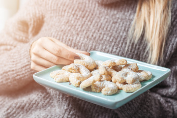 Junge Frau isst Vanillekipferl 