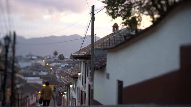 colonial street view at evening time, lonely man passing on street in ancient town  San Cristobal de las Casas