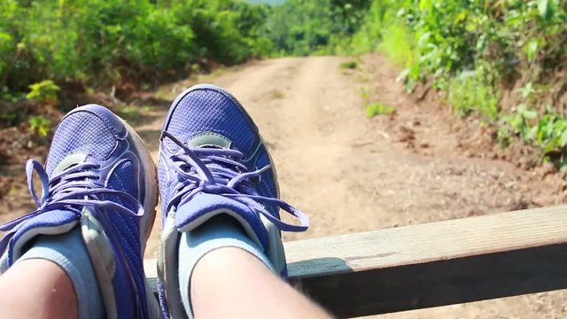 Close up sport shoes on adventure car for dependent woman traveler, looking at view country home around in forest at Loei, Thailand Enjoying mountain travel adventures. 