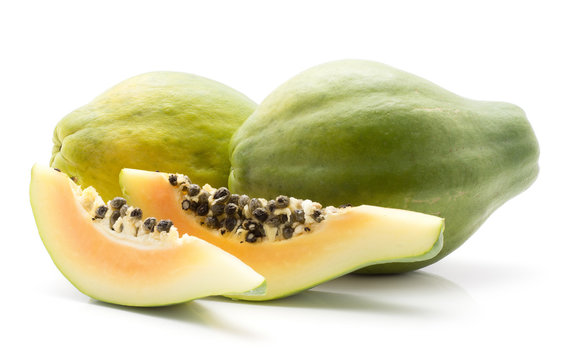 Green papaya (pawpaw, papaw) two whole two slices with black seeds isolated on white background.