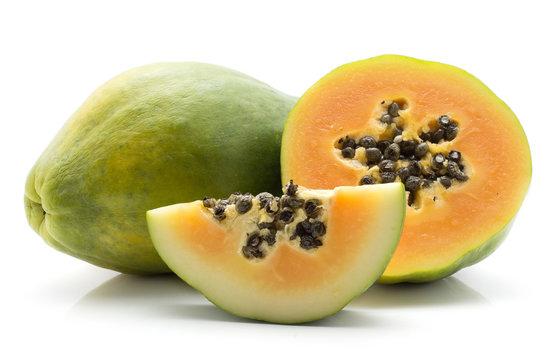 Green papaya (pawpaw, papaw) one whole half and slice isolated on white background.