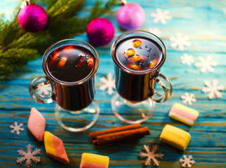 A hot drink of mulled wine and spices on a wooden background