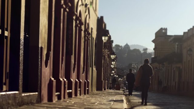 sunny morning  people in silhouette wolking on colonial street in ancient town  San Cristobal de las Casas