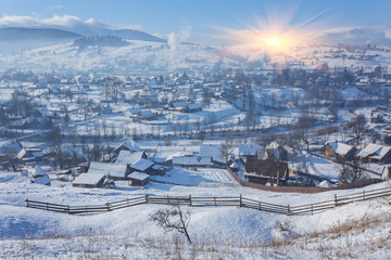 Obraz premium Rural alpine winter landscape with fence and path