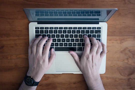 mans hands on apple laptop