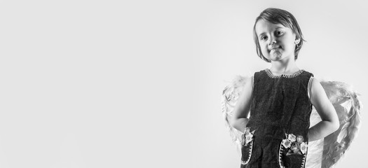 Child girl with angel wings as symbol of goodness, security, protection and happy childhood