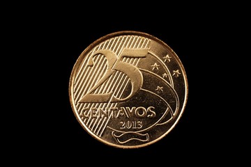 A super macro image of a 25 centavo Brazilian coin isolated on a black background