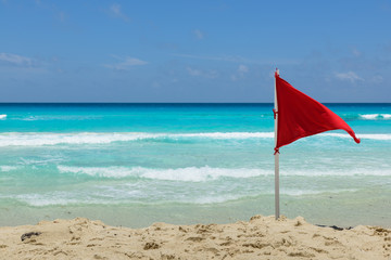 Fototapeta na wymiar Red Flag On the Beach, Cancun, Mexico