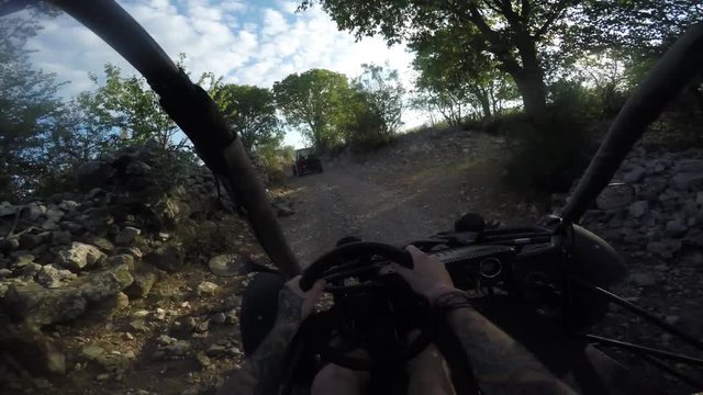 Gopro shot of young man driving dune buggy on a dirtroad