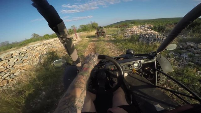 Gopro shot of young man driving dune buggy on the countryside behind another