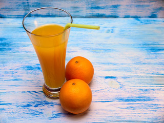 oranges and orange juice on a wooden light background