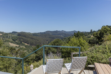 Fototapeta premium Amazing patio / wooden deck with outdoor furniture and mountain view at daytime.