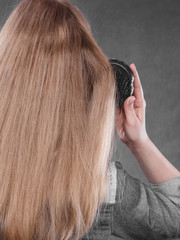 Fototapeta premium Blonde woman combing her hair.