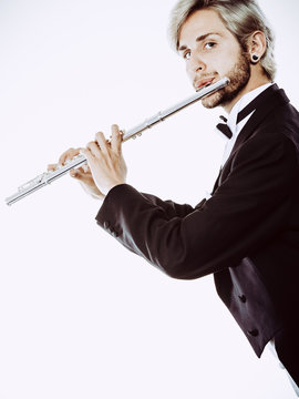 Male flutist wearing tailcoat plays flute