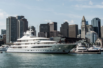 Obraz premium Yacht and sailing boats on Charles River in front of Boston Skyline in Massachusetts USA on a sunny summer day