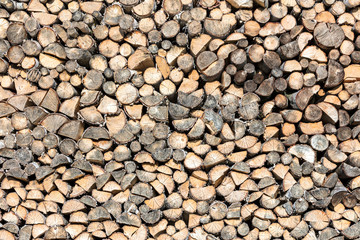 stack of chopped firewood prepared for winter. natural wood background.