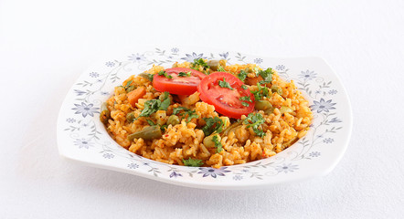 Tomato rice pilaf or tomato rice bath, an Indian vegetarian breakfast, with garnishing of fresh tomato slices and coriander leaves.