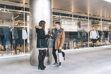 Young beautiful in love couple shopping around the street .