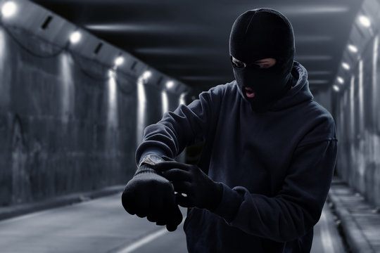 Masked thief waiting in tunnel
