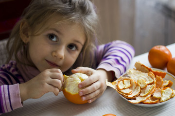 Child and tangerine, orange. Selective focus.