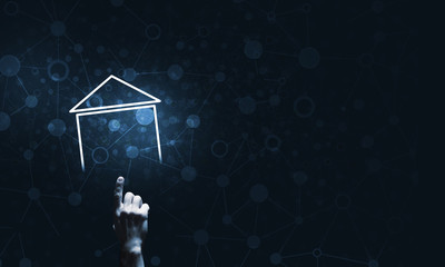 Conceptual image with hand pointing at house or main page icon on dark background