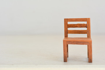 Close up of miniature toy chair on wood table. Copyspace can be used for your text.