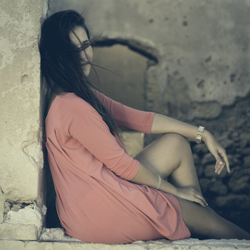 Close up of a 18Y old Girl Sitting in a Window of a Ruined House (location: Plemmirio Natural Park, Siracusa in Sicily)