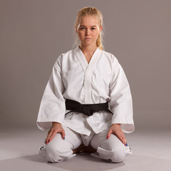 Woman sitting in a traditional karate pose. © papa