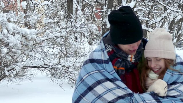 The couple is warmed by a rug on the street