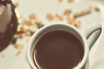 chocolate cake on the white plate with a cup of coffee, food macro photography decoration concept for new year party.