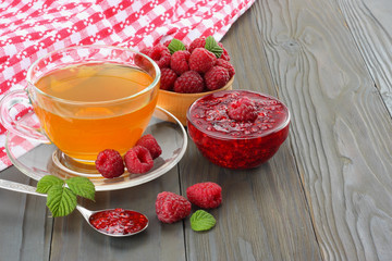 healthy background. raspberry with raspberry jam and tea on dark wooden background