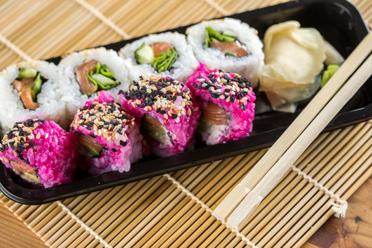 Modernes Lachs Sushi Men&uuml; mit California Inside Out Rollen in Pink Avocado und Rocula Gurke 