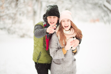 Obraz premium Romantic couple walking in the street. A boys sees something funny and shows his girlfriend.