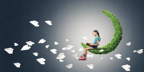 Concept of careless happy childhood with girl on green moon