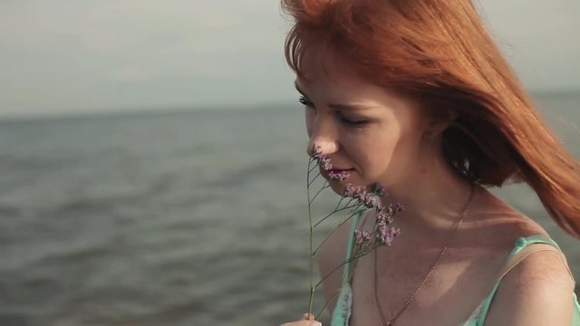 Sexy girl with a flower on the sea