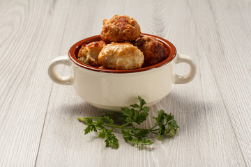 Fried meat cutlets in white ceramic soup bowl and branch of fresh parsley