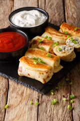 Crepes rolls with chicken and mushrooms close-up, and tomato sauce, sour cream. vertical