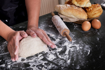 Woman's hands knead dough with flour, eggs and ingredients. at kitchen.
