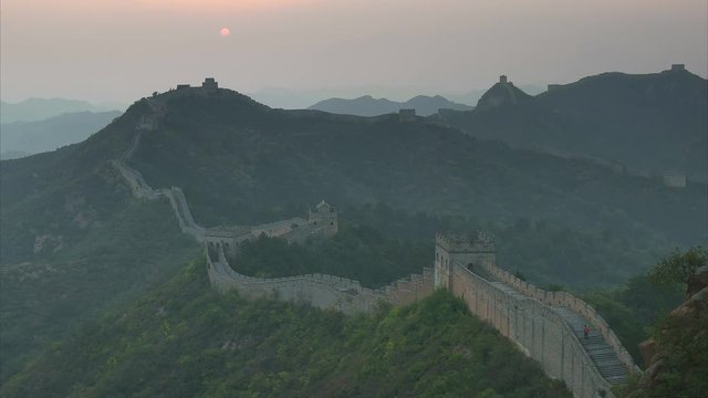 the sun setting over the great wall of china at jinshanling