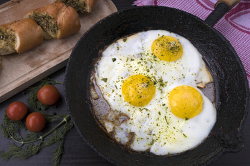 appetizing fried eggs in an old frying pan