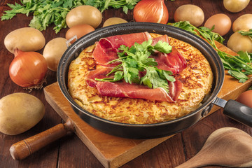 A closeup photo of a Spanish tortilla with ingredients